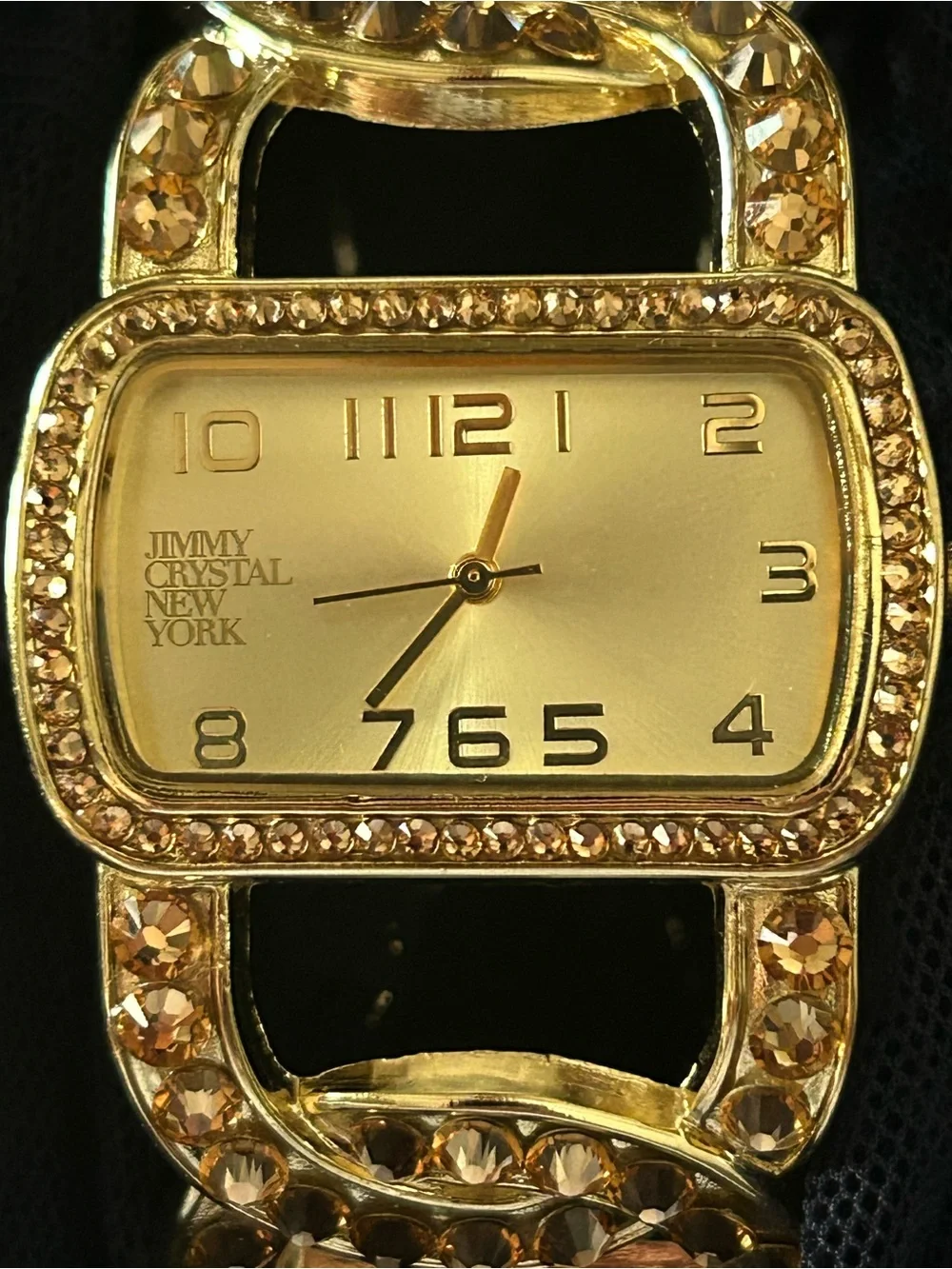 Jimmy Crystal elegant gold tone cuff watch with sparkling crystal accents.